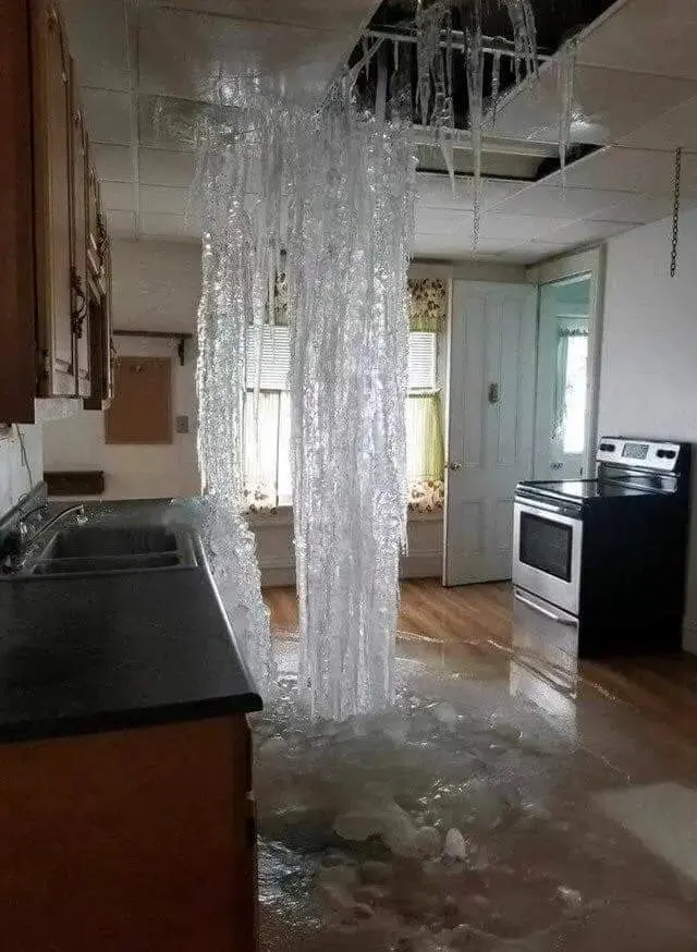 Water pouring through an opened kitchen ceiling from a leak above in Hayward